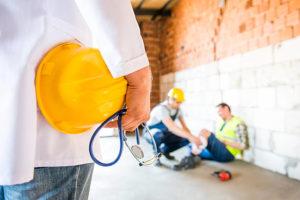 Doctor walking towards injured worker sitting on the floor